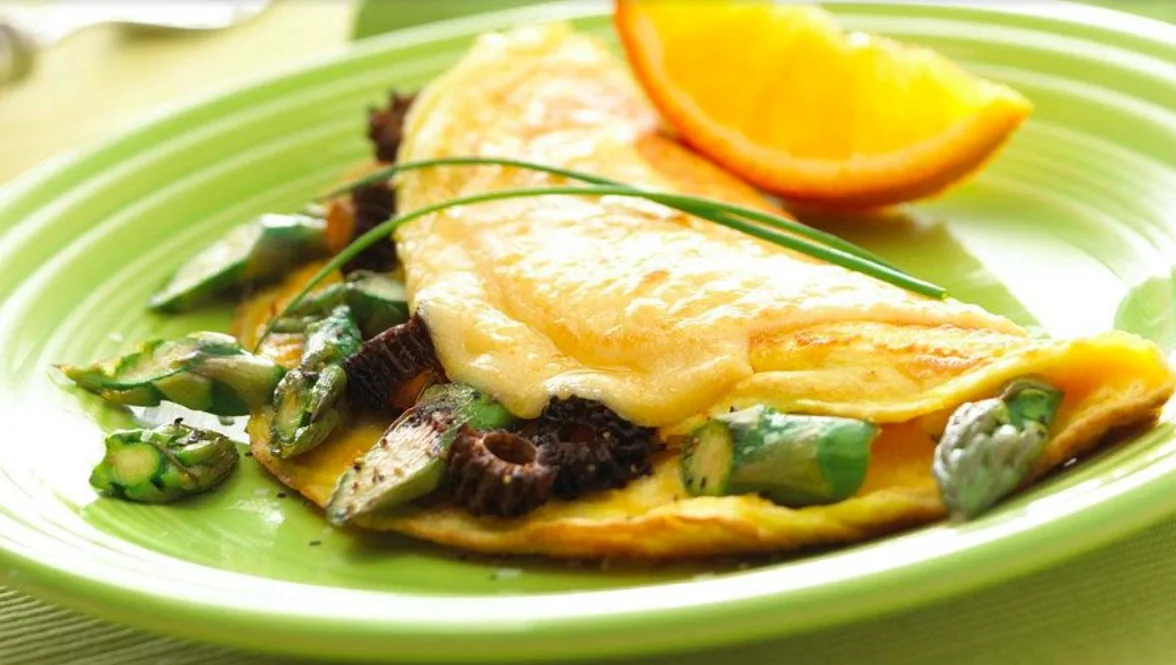 Omelette with asparagus and mushrooms, served with a wedge of fresh orange